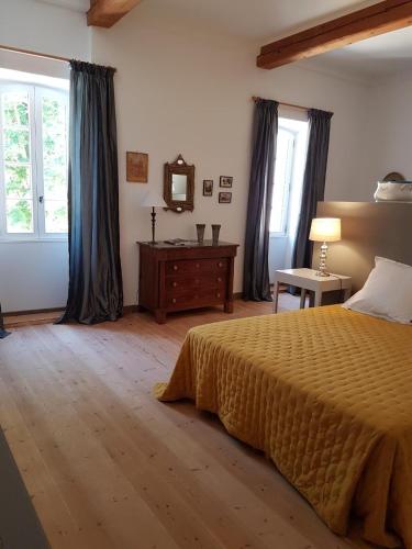 1 dormitorio con cama y mesa con espejo en domaine de Capoulade, en Narbona