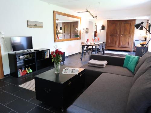 sala de estar con sofá y mesa en Apartment Grangettes by Interhome, en Noville