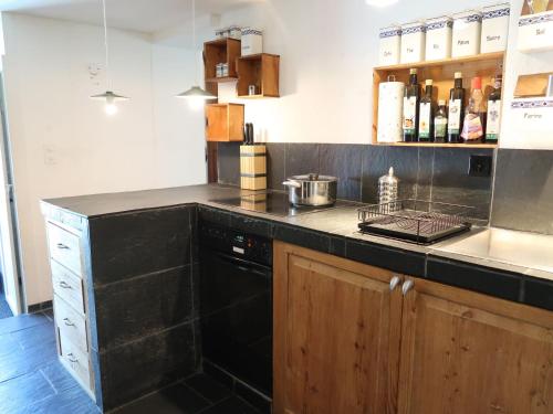 eine Küche mit einer schwarzen Arbeitsplatte und einem Geschirrspüler in der Unterkunft Apartment Grangettes by Interhome in Noville