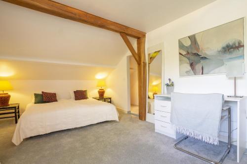 une chambre avec un lit et un bureau dans une pièce dans l'établissement Boutouzet, à Villeneuve-sur-Lot