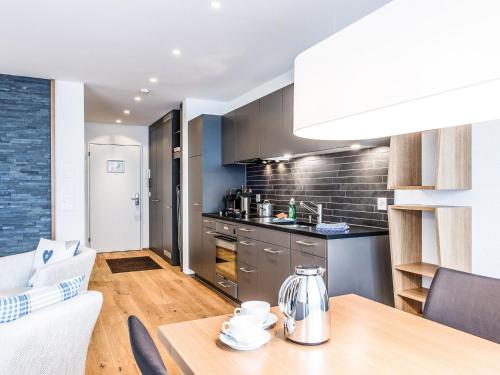een keuken en een woonkamer met een houten tafel bij Apartment TITLIS Resort Studio 5 by Interhome in Engelberg