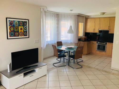 ein Wohnzimmer mit einem Tisch und einer Küche in der Unterkunft Apartment Edelweiss C by Interhome in Leukerbad