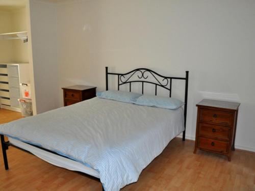 ein Schlafzimmer mit einem Bett und zwei Nachttischen in der Unterkunft The Dwicke in Brentwood