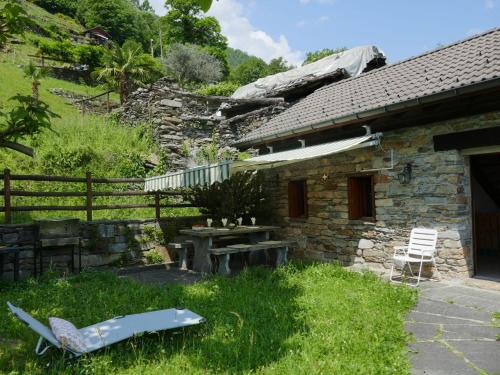 a stone house with a bench and a fence at Holiday Home Rustico Cleo by Interhome in Semione