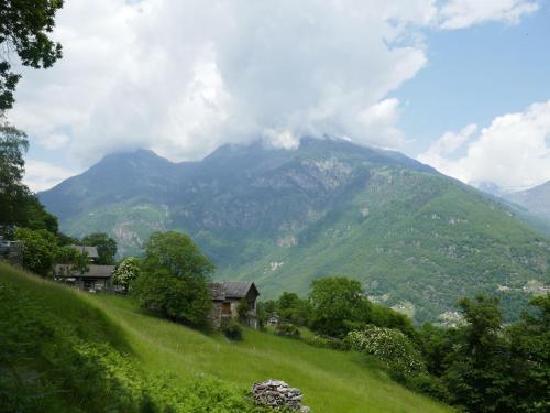 a green hill with a house and a mountain at Holiday Home Rustico Cleo by Interhome in Semione