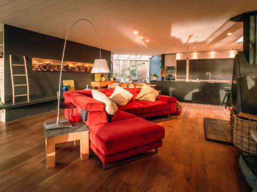 a living room with a red couch and a red chair at Villa Domicile adoré by Interhome in Ostend