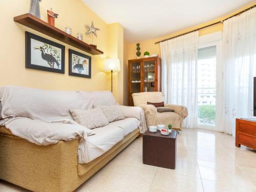 una sala de estar con un sofá y una silla en Apartment Mirador de Llandels II by Interhome, en Peñíscola