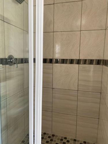 a shower with a glass door in a bathroom at Mercy Land Guesthouse in Matatiele