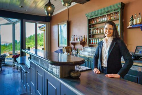 a woman standing at a counter in a bar at Kleivstua Hotel near Krokskogen in Sundvollen