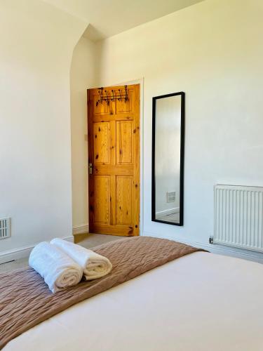 a bedroom with a bed with a mirror and a door at 18 Horner Street in York