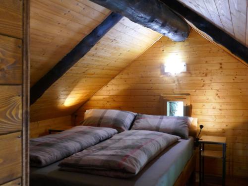 a bed in the attic of a wooden cabin at Chalet Casa Sosto by Interhome in Castro