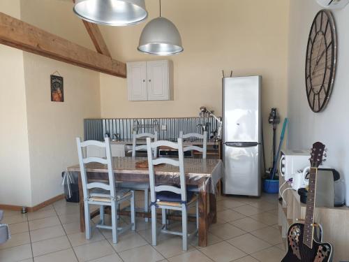 uma cozinha com uma mesa e cadeiras e um frigorífico em Canal du Midi Argeliers Gîte 4 personnes em Argeliers