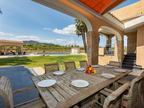 a wooden table with plates of fruit on a patio at Villa Finca Villa Roig by Interhome in Peniscola