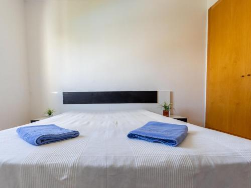 two blue towels are sitting on a white bed at Holiday Home Zona Estival-3 by Interhome in Salou