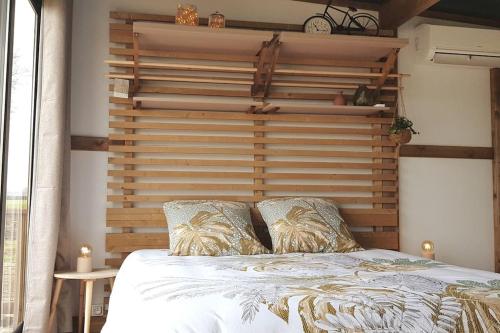 - une chambre avec une tête de lit en bois dans l'établissement Tiny House à la campagne, à Saint-Yan