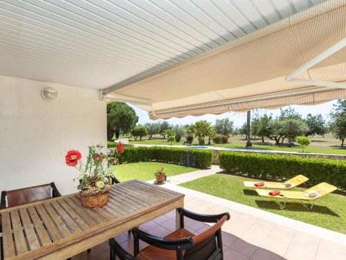 an outdoor patio with a wooden table and chairs at Apartment Gabriel by Interhome in Sant Jordi