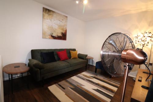 a living room with a couch and a fan at Central Modern House, Greenhithe in Kent