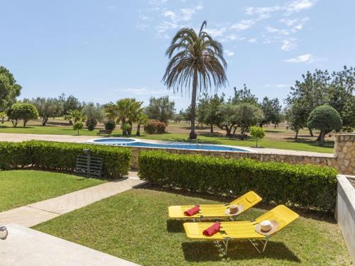 two yellow lounge chairs in the grass near a pool at Apartment Gabriel by Interhome in Sant Jordi