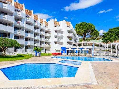 a swimming pool in front of a large apartment building at Studio Eurhostal - Seaview by Interhome in Alcossebre