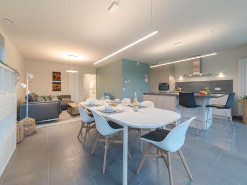 uma cozinha e sala de estar com uma mesa branca e cadeiras em Apartment koningstern by Interhome em Bredene