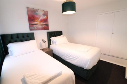 - 2 lits dans une chambre avec des draps blancs dans l'établissement Central Modern House, Greenhithe, à Kent