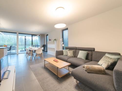 uma sala de estar com um sofá e uma mesa em Apartment koningstern by Interhome em Bredene