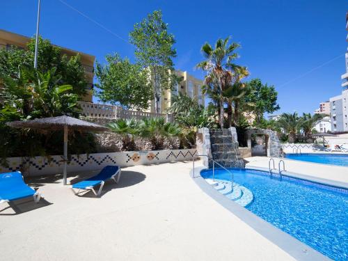 een zwembad met 2 stoelen en een parasol bij Apartment Turquesa Beach-6 by Interhome in Calpe