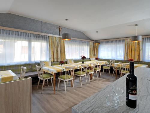 フューゲンにあるHoliday Home Apart Anneliese by Interhomeのダイニングルーム(テーブル、椅子付)、ワイン1本