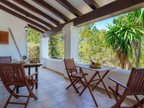 um pátio com uma mesa e cadeiras e uma palmeira em Holiday Home Pitiusa by Interhome em Es Pujols