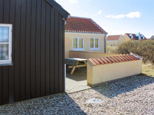 a house with a picnic table next to a fence at Holiday Home Nille - 100m from the sea by Interhome in Skagen