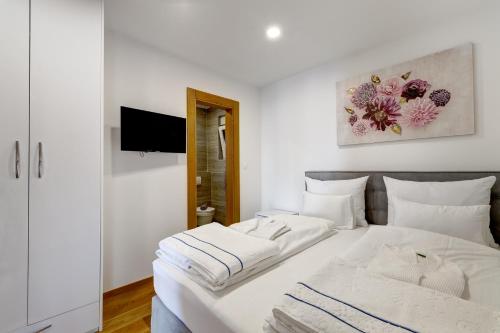 um quarto com 2 camas brancas e uma televisão em Villa Zara em Dramalj