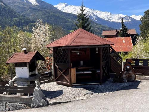 a small building with a stove and mountains in the background at Apartment Hüttaler by Interhome in Dorf
