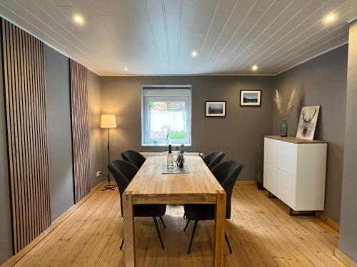 a dining room with a wooden table and black chairs at Holiday Home Familie Zinser by Interhome in Hemfurth-Edersee
