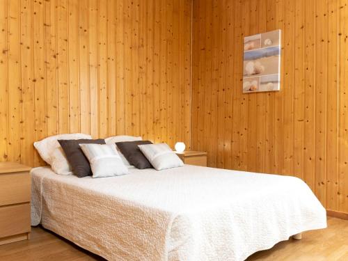 1 dormitorio con 1 cama blanca y paredes de madera en Apartment le Malouin by Interhome en Saint-Malo