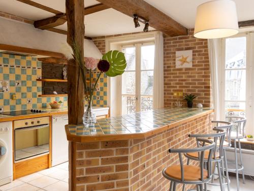 - une cuisine avec un mur en briques et un bar avec tabourets dans l'établissement Apartment le Malouin by Interhome, à Saint-Malo