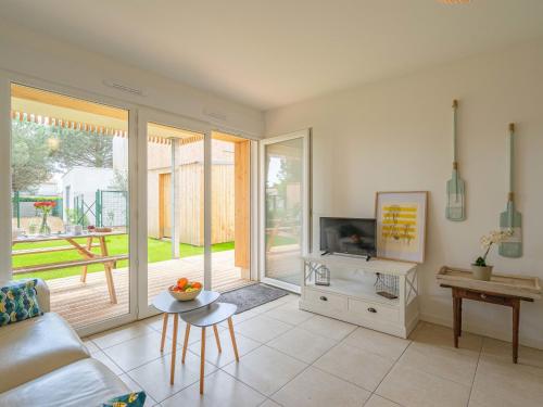 un salon avec un canapé et une télévision dans l'établissement Apartment Wangari by Interhome, à Vaux-sur-Mer