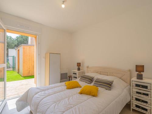- une chambre avec un lit blanc et 2 oreillers jaunes dans l'établissement Apartment Wangari by Interhome, à Vaux-sur-Mer