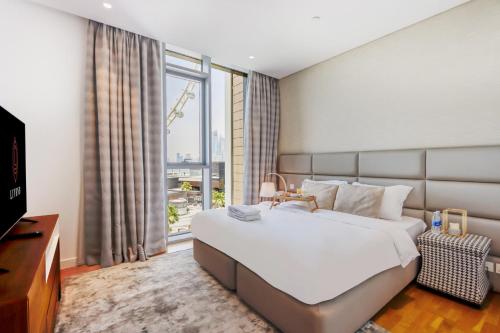 a bedroom with a large bed and a large window at Bluewater Island - Bright 2 BR Suite with Dubai Eye View by Livbnb in Dubai