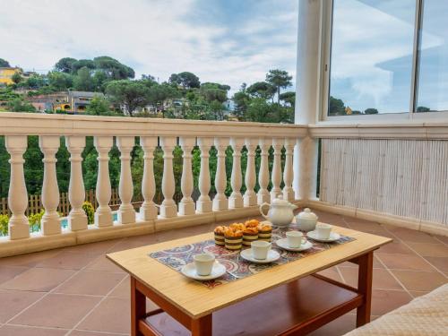 una mesa con tazas y naranjas en el balcón en Holiday Home Armonia by Interhome, en Maçanet de la Selva