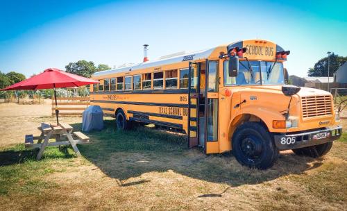 a yellow school bus parked next to a picnic table at American School Bus Glamping - Somerset in Cheddar