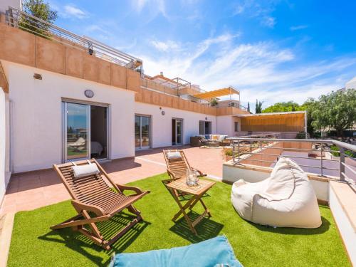 a patio with two chairs and a couch on the grass at Apartment Cima del Mar-9 by Interhome in Pego