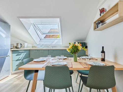a kitchen with a wooden table and green chairs at Apartment Le laizon 2 by Interhome in Croissanville
