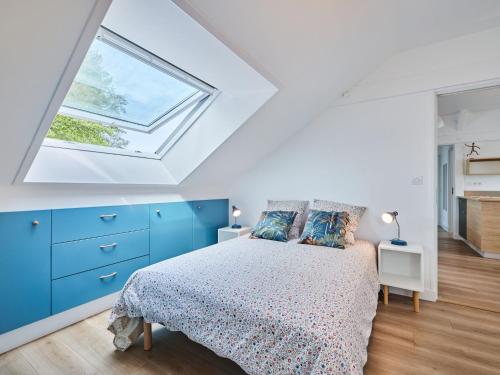 a bedroom with a bed with blue cabinets and a window at Apartment Le laizon 2 by Interhome in Croissanville
