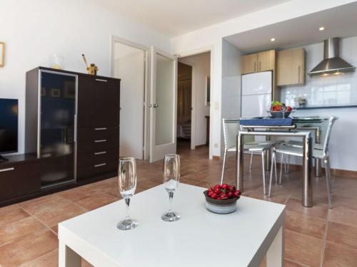 a kitchen and living room with two wine glasses on a table at Apartment Cavall Bernat by Interhome in Platja  d'Aro