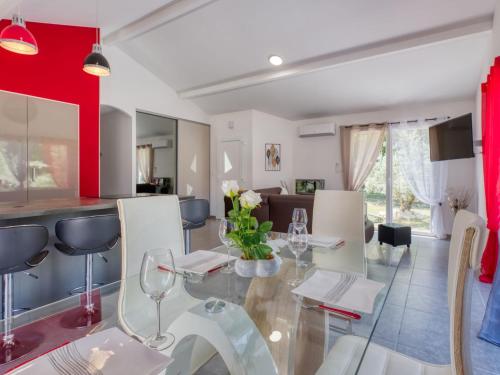 une salle à manger et une cuisine avec une table et des chaises en verre dans l'établissement Holiday Home Plassan by Interhome, à Lesparre-Médoc