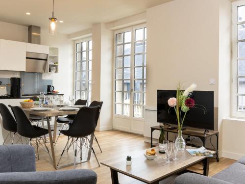 a living room with tables and chairs and a kitchen at Apartment Plasenn by Interhome in Saint Malo