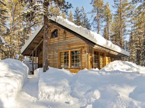 a log cabin in the woods in the snow at Holiday Home Harvana by Interhome in Kittilä