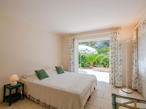 une chambre avec un lit et une grande fenêtre dans l'établissement Villa Les Dauphins by Interhome, à Saint-Aygulf