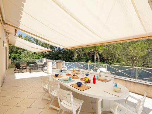 d'une terrasse avec une table et des chaises blanches. dans l'établissement Villa Les Dauphins by Interhome, à Saint-Aygulf