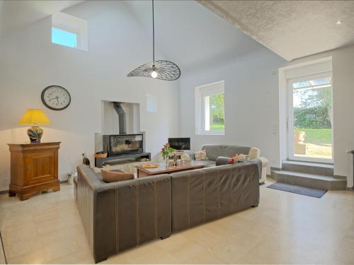 uma sala de estar com um sofá grande e um relógio em Holiday Home Ker Yannick by Interhome em Hillion